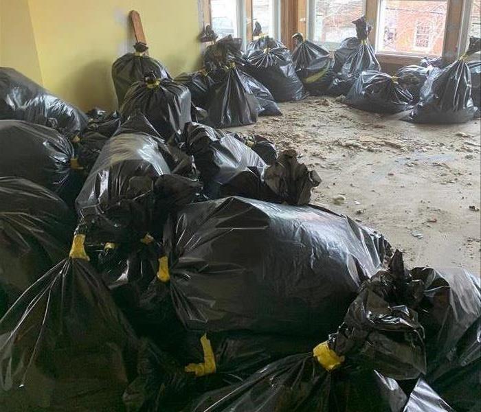 several black trash bags full of debris